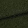 Dark olive‑green bouclé fabric, folded in a shallow horizontal overlap, showing dense looped texture; close-up studio view emphasizing a tactile, slightly shadowed surface.