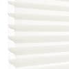 White horizontal pleated cellular blind with scalloped edges, fully lowered and closed, filtering bright daylight; close-up view showing soft shadowed ridges against a pale background.