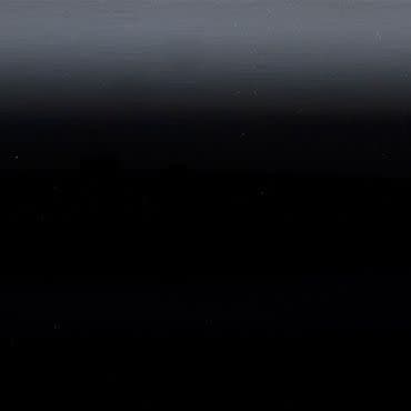 Horizontal dark gradient panel (object) showing faint horizontal banding and tiny light specks, appearing smooth and slightly reflective (action); occupying the entire frame in an abstract, low-light scene (context).