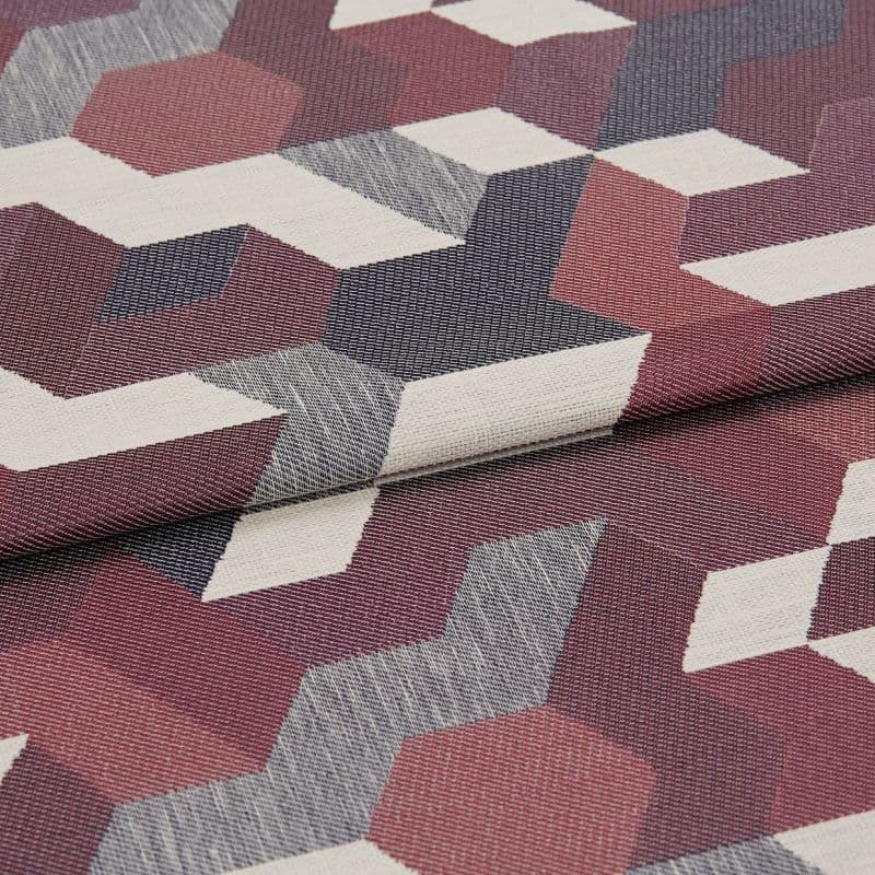 Woven jacquard fabric with burgundy, navy, gray and off‑white 3D cube pattern; folded once with overlapping edge; close-up on a flat surface under soft, diffuse studio lighting.