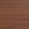 Horizontal walnut veneer panel filling the frame, displaying fine straight grain and subtle sheen; resting flat as a tabletop or shelf surface in soft, even indoor lighting.