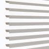 Zebra-style roller blinds, horizontal alternating sheer and opaque taupe stripes across a vertical window, aligned and partly open, filtering soft daylight against a bright white background in a close-up shot.