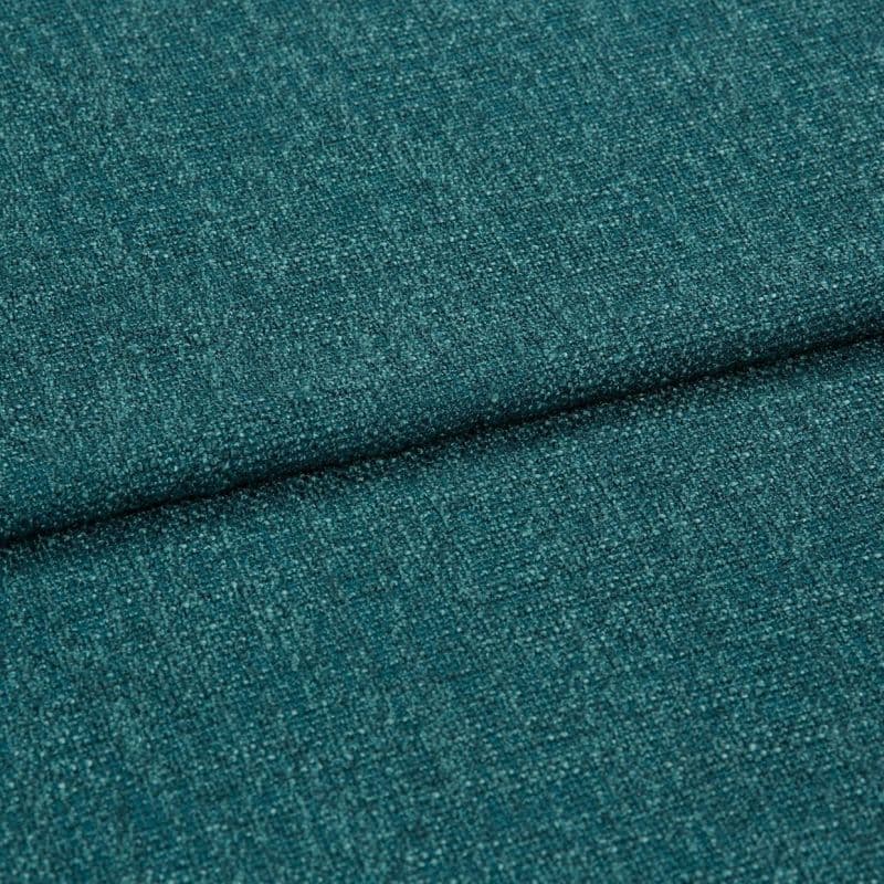 Teal woven upholstery fabric, close-up of a folded seam showing textured boucle-like weave; the fabric is folded diagonally across the frame, lit evenly in soft studio lighting.