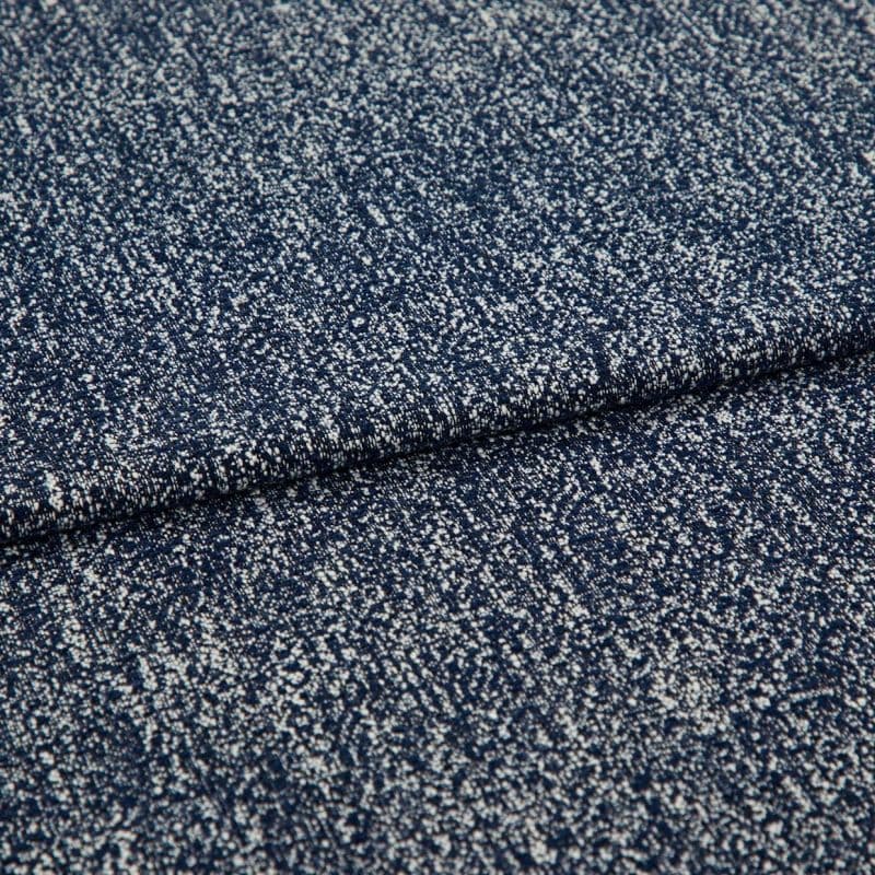 Folded speckled navy woven fabric close-up showing dense white fleck pattern; fabric lies layered and slightly overlapping, highlighting textured weave under soft studio lighting on a neutral background.