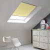 Room with white eaves wall, dark blue-grey wall to right with a shabby chic white drawer unit, a contemporary white chair, white painted floorboards and a skylight blind in lemon.