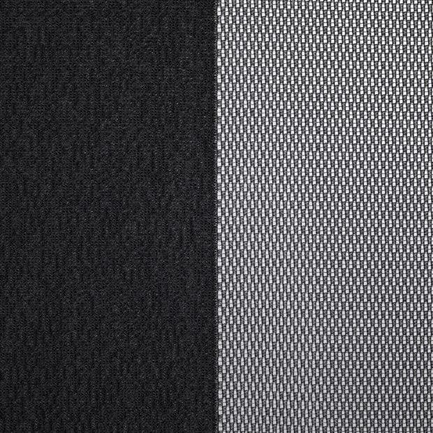 Two window dressings — a solid black blackout curtain (left) and a white woven sheer panel (right) — hang closed, the sheer filtering light; close-up interior view with neutral lighting.