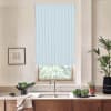 Blue-striped roller blind covers a kitchen window above a stainless-steel faucet; light filters through. On the countertop: a bowl of greens, potted herbs, folded towel, framed sketch and tall plant.