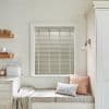 Horizontal slatted Venetian blinds (inside-mounted, beige-grey slats) closed, filtering soft daylight into a bright kitchen window seat with cushions, built-in bench, shelves, and pale walls.
Transcription: BREAD
TASTING ROME
THE PIG