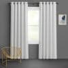 White grommet-top curtains, full-length, hung on a bronze rod and parted to reveal the window while filtering soft daylight; set against a dark gray wall in a minimal room with a gold wire chair and abstract art.