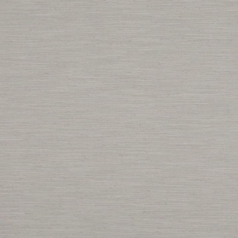 A light grey-beige woven roller blind, fully lowered and opaque, filtering soft daylight; neutral textured fabric fills the frame, suggesting a closed window in a softly lit interior.