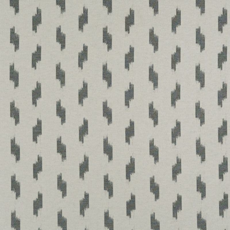Woven beige fabric featuring staggered dark-gray abstract brushstroke motifs; motifs repeat in vertical columns, forming a regular geometric pattern across a flat, evenly lit close-up surface.