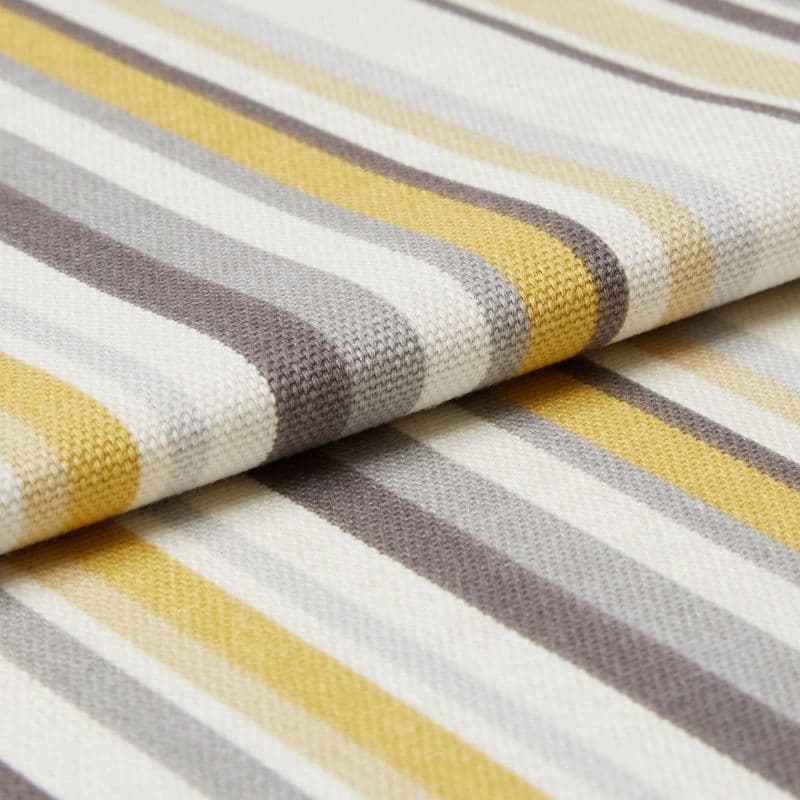 Striped woven fabric with textured knit — yellow, gray, beige and white bands — folded over itself, close-up on a flat surface under soft studio lighting.