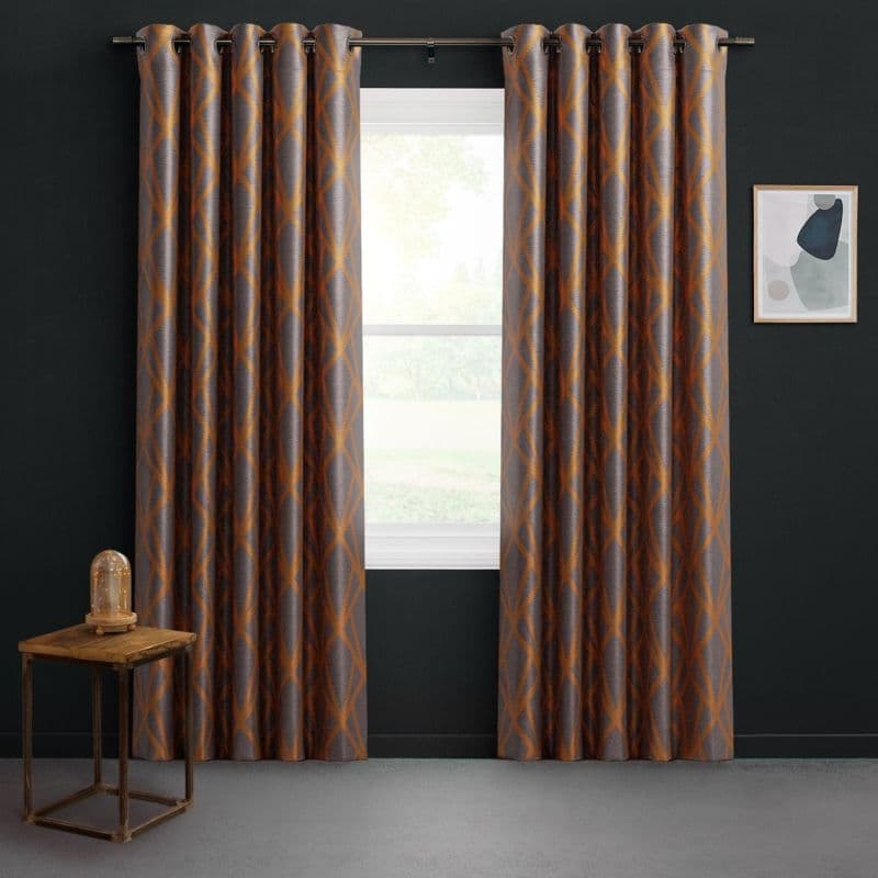 Grommet-top patterned curtains with orange-brown lattice, hung on a metal rod, partially open and filtering daylight through the window; dark-walled room with wooden side table and framed abstract art.