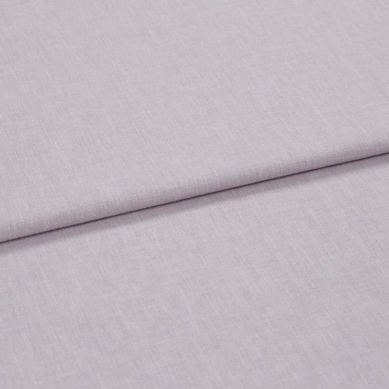 A folded pale lavender woven fabric, folded once to create a horizontal overlap, close-up on a flat surface with soft, diffuse lighting highlighting the subtle weave texture.