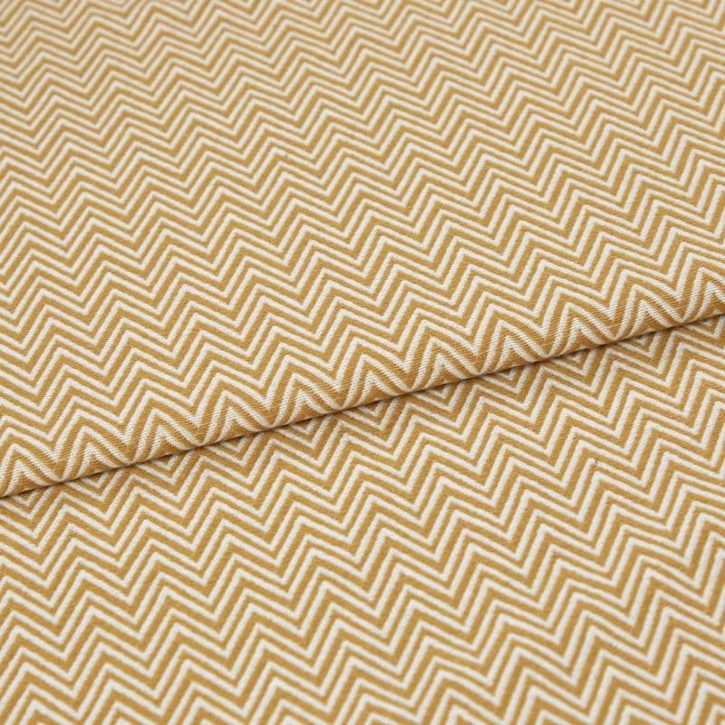 Mustard-and-white chevron fabric, tightly woven, folded across the frame; pattern repeats in narrow zigzags. Close-up view showing textured weave and soft, even lighting on a flat surface.