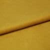 Mustard-yellow fabric, folded once with a visible textured edge, lying flat; soft pile catching even studio lighting, close-up composition emphasizing a smooth, plush surface.