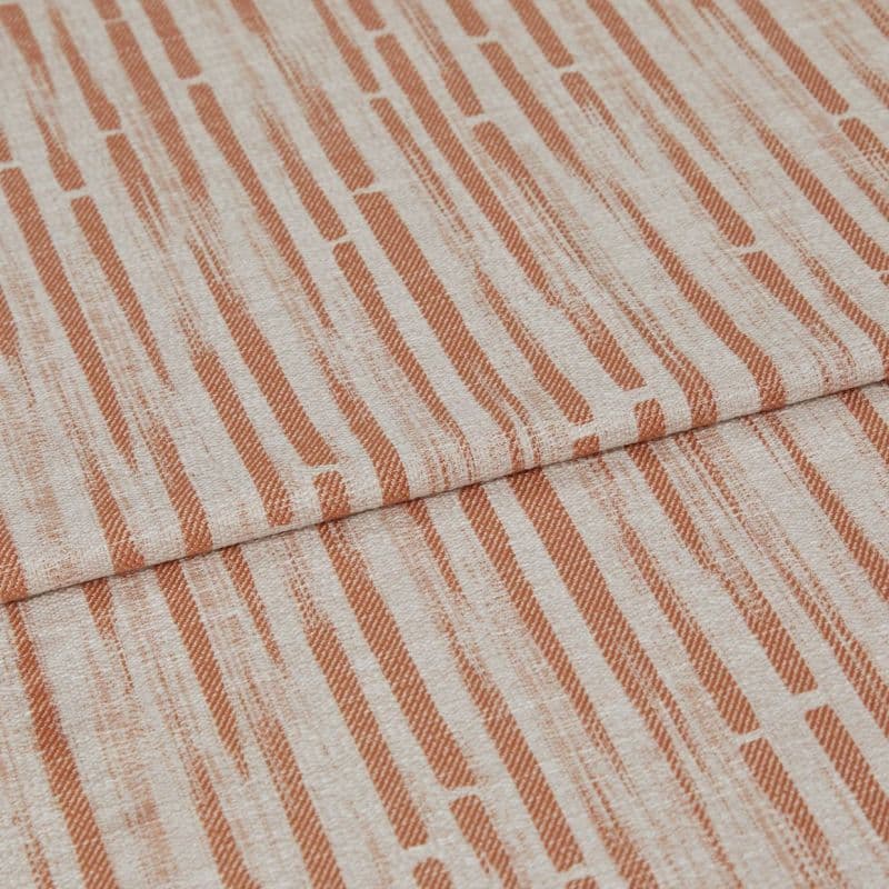 Textile fabric with rust-orange vertical dash pattern (linen-like texture), folded once so one panel overlaps another, displayed as a swatch under soft, even lighting — close-up, neutral background.