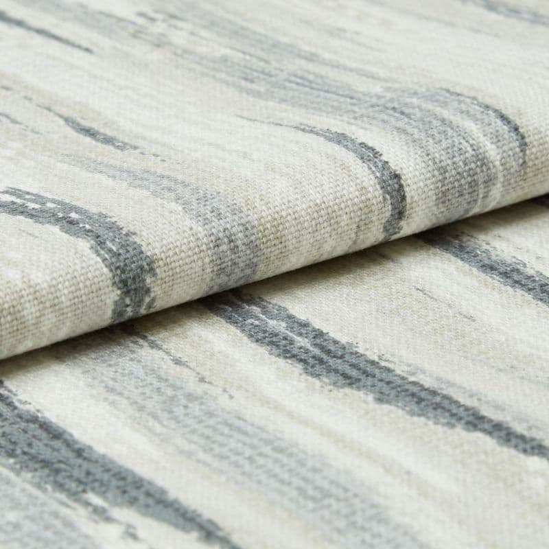 Off-white woven fabric with irregular gray horizontal brushstroke pattern; folded over itself showing textured weave; close-up studio view with soft, diffuse lighting.